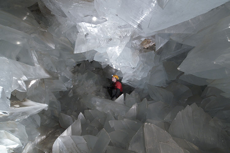 Geologist surrounded by crystals inside of a geode