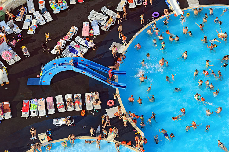 People lounging and swimming at a crowded pool