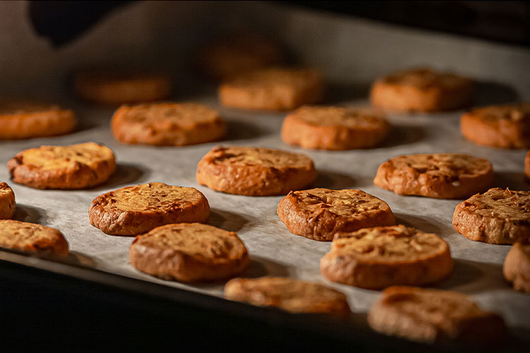 Image of baked chocolate chip cookies on a pan in the oven