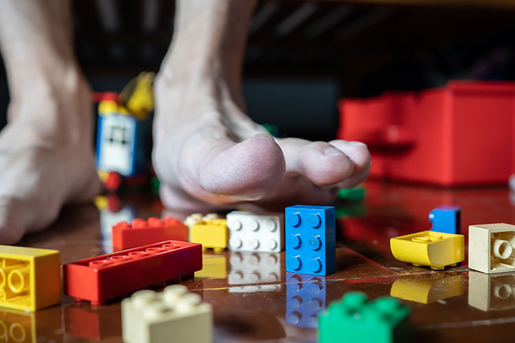 Image of feet stepping on legos