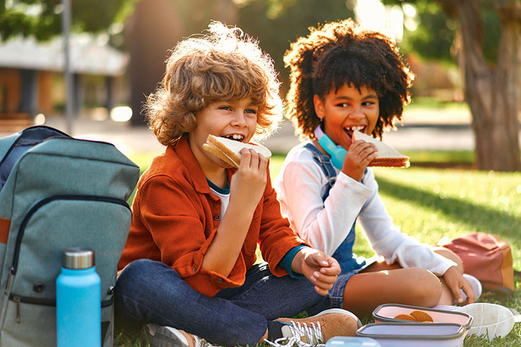 Image of kids eating lunch outside together