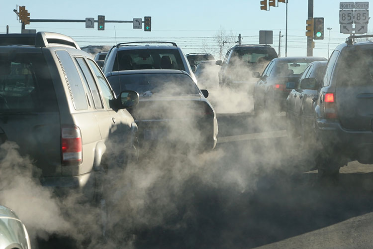 Image of car exhaust polluting the air at a traffic light